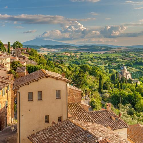 Panorama di colline verdi e case antiche in un borgo toscano.