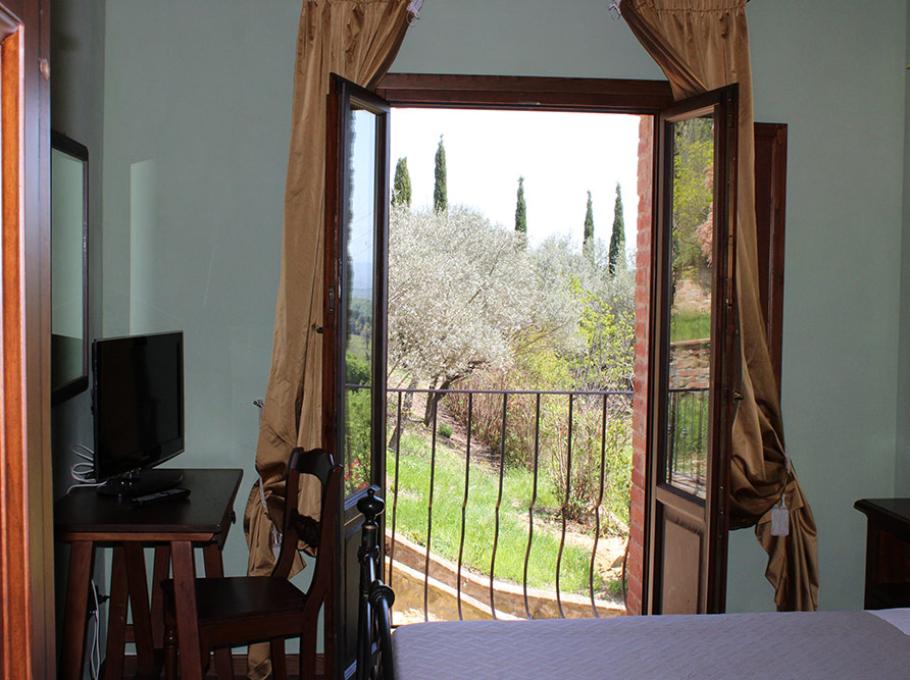 Camera elegante con letto in ferro battuto e cuscini decorati, lampade e fiori.