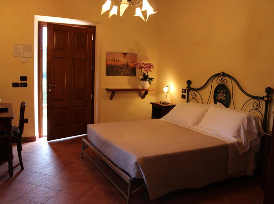 Camera da letto con arredi classici, letto in ferro battuto e lampade eleganti.