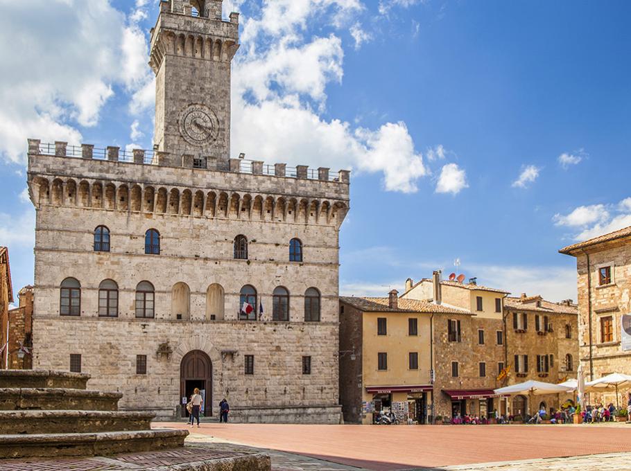 Scogliera bianca che si affaccia su acque turchesi, con paesaggio collinare sullo sfondo.